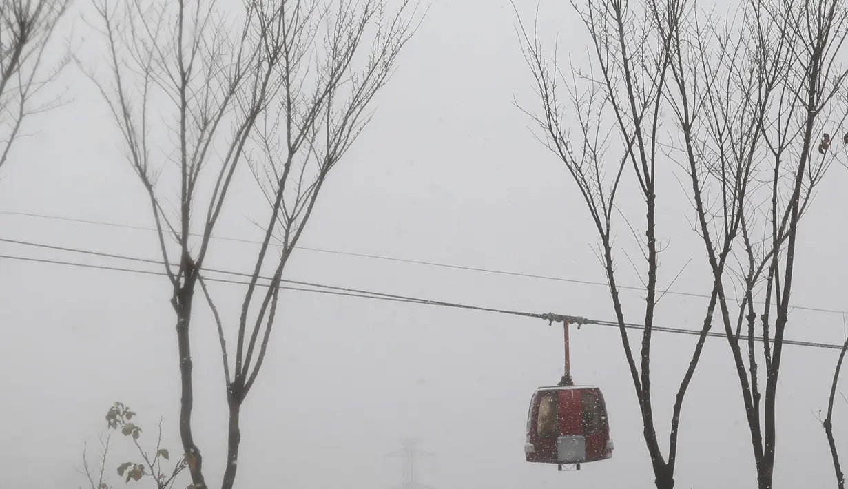 Gondola bergerak maju dalam cuaca bersalju di daerah pegunungan yang menghadap ke ibukota Teheran, Iran (18/12/2021). (AP Photo/Vahid Salemi)