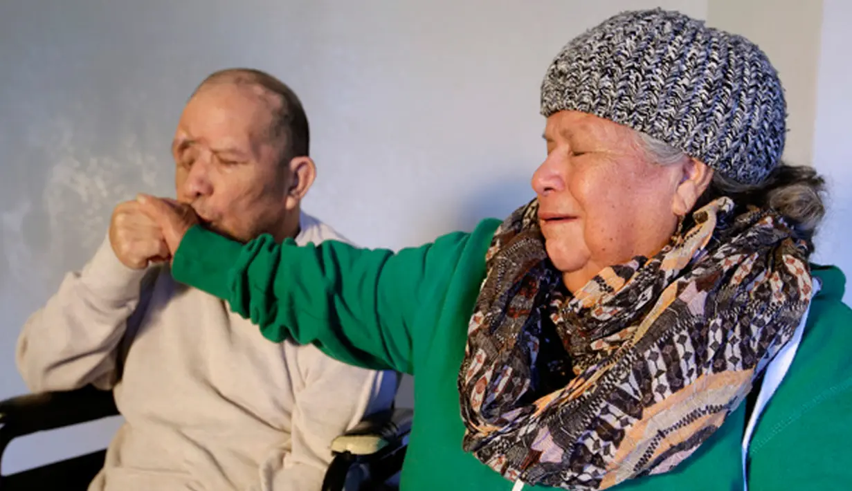 Walter DeLeon mencium tangan ibunya sambil menceritakan kejadian penembakan oleh petugas kepolisian Los Angeles yang membuatnya mengalami kesulitan untuk berbicara di Covina, California, Rabu (2/12/2015). (AP/Chris Carlson/Dailymail)