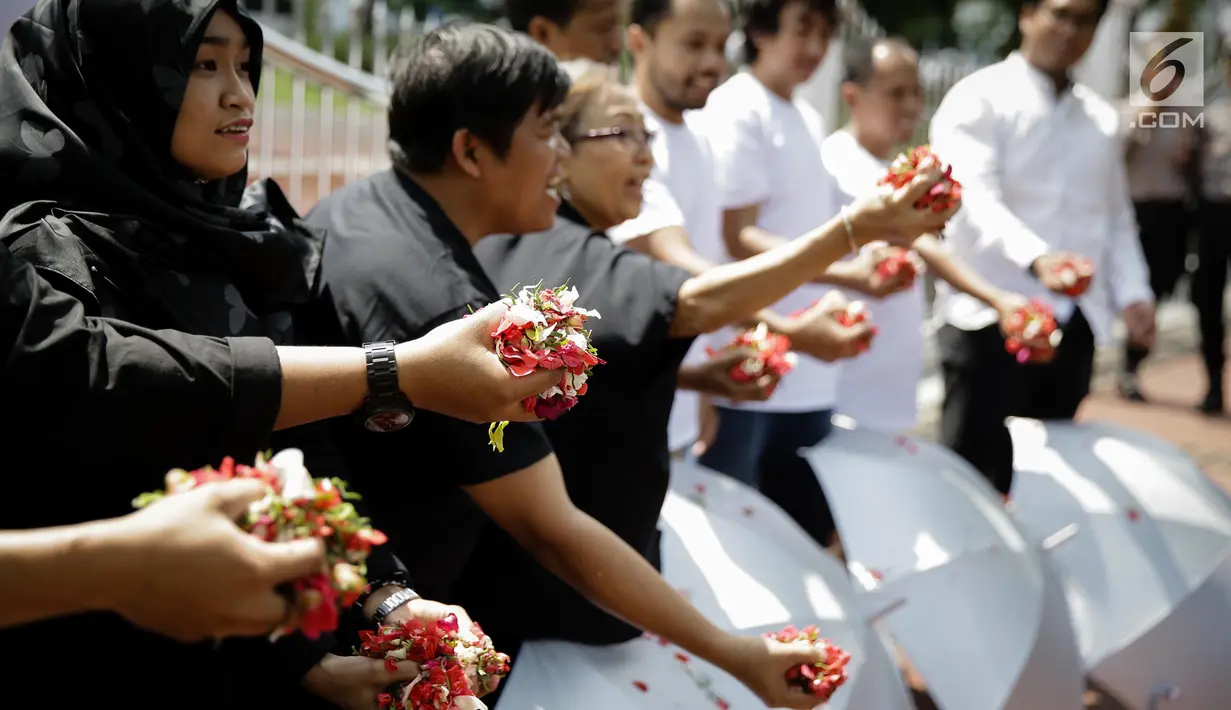 Sejumlah massa yang tergabung dalam Koalisi Masyarakat Sipil Penegak Citra DPD menaburkan bunga pada payung sebagai bentuk simbol kekhawatiran matinya keadilan dan penegakan hukum di depan Mahkamah Agung, Jakarta, Rabu (7/6). (Liputan6.com/Faizal Fanani)