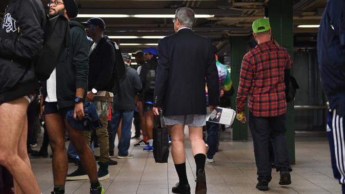 Peserta acara tahunan No Pants Subway Ride menunggu untuk menaiki kereta di stasiun bawah tanah di New York pada Minggu (12/1/2020). New York menjadi kota pertama yang menghajat acara naik kereta tanpa celana ini sejak tahun 2002. (Johannes EISELE / AFP)