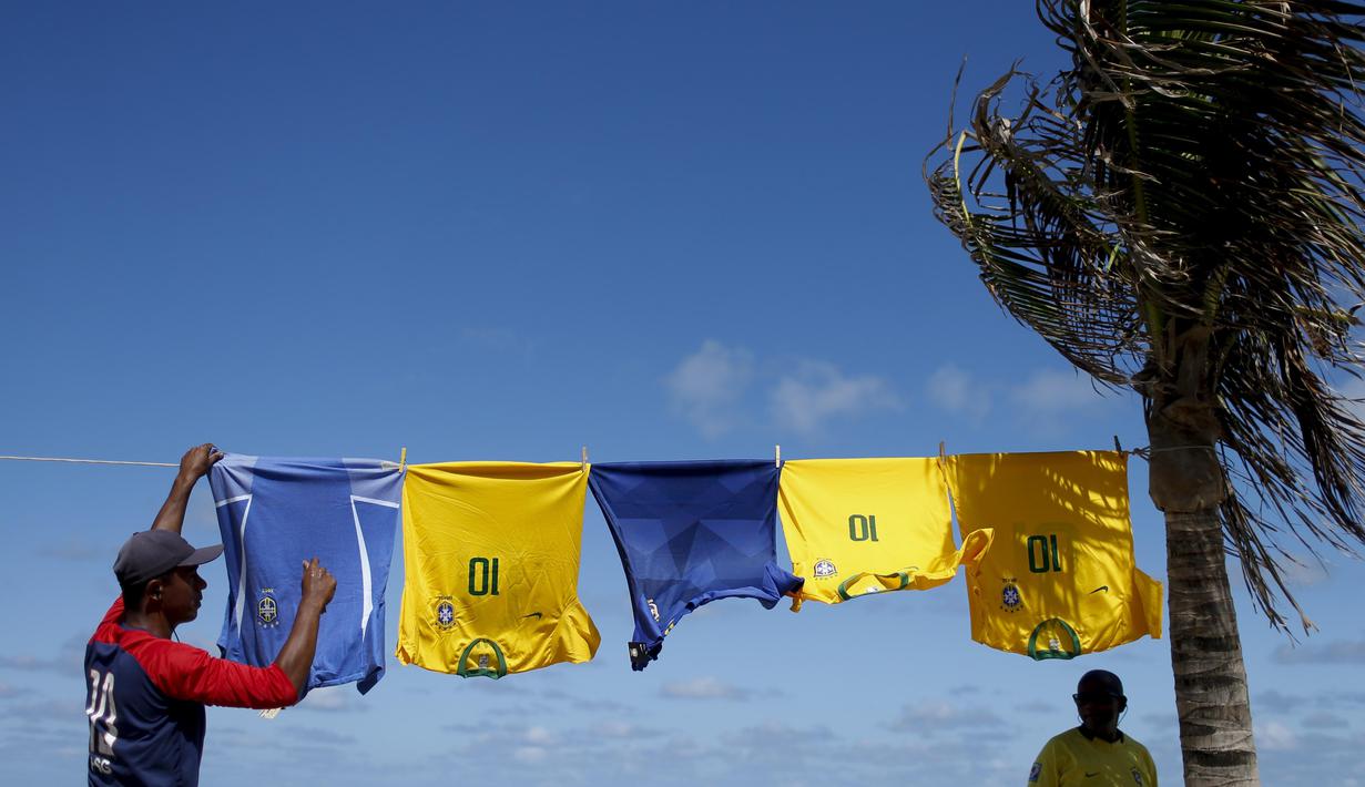 Para pedagang kaki lima menjual jersey timnas Brasil di sekitar stadion Arena Fonte Nova, Salvador, Brasil. (AP/Natacha Pisarenko)