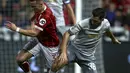 Pemain Bristol City, Joe Bryan berebut bola dengan pemain Manchester United, Matteo Darmian pada perempat final Piala Liga Inggris di Ashton Gate, Kamis (21/12). MU tersingkir dari Piala Liga Inggris setelah takluk 1-2. (Geoff CADDICK / AFP)