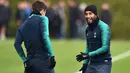 Gelandang Tottenham Hotspur, Lucas Moura tertawa saat sesi latihan di Pusat Pelatihan Enfield, London utara (12/2). Tottenham akan bertanding melawan Borrusia Dortmund pada 16 besar Liga Champions di stadion Wambley. (AFP Photo/Glyn Kirk)