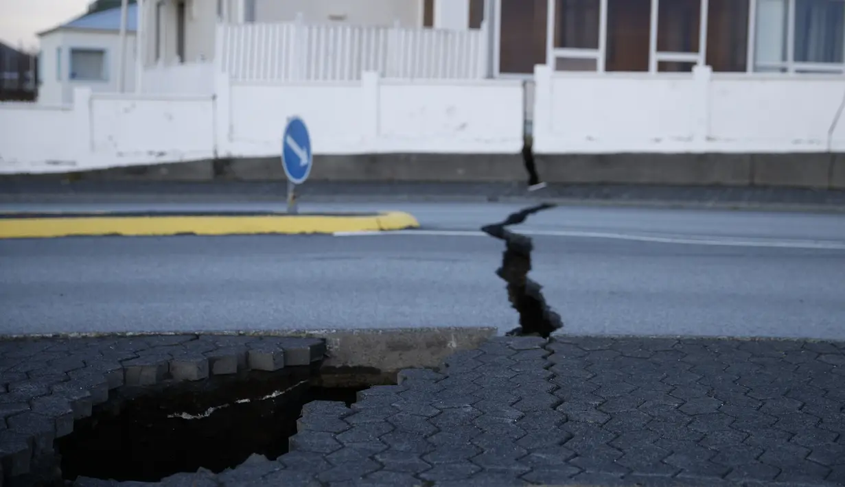 Retakan-retakan mulai terlihat di jalan-jalan, menunjukkan kerusakan yang terlihat akibat gempa. (AP Photo/Brynjar Gunnarsson)