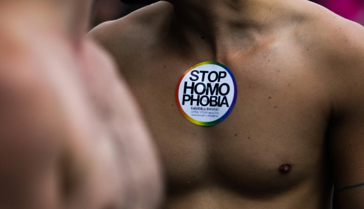 Seorang pria berpose dengan stiker ‘Stop Homophobia’ menempel di dadanya saat parade ‘Gay Pride’ di Berlin, Jerman, Sabtu (22/7). Sebanyak 393 anggota parlemen Jerman menyetujui pernikahan sesama jenis. (AP/Markus Schreiber)