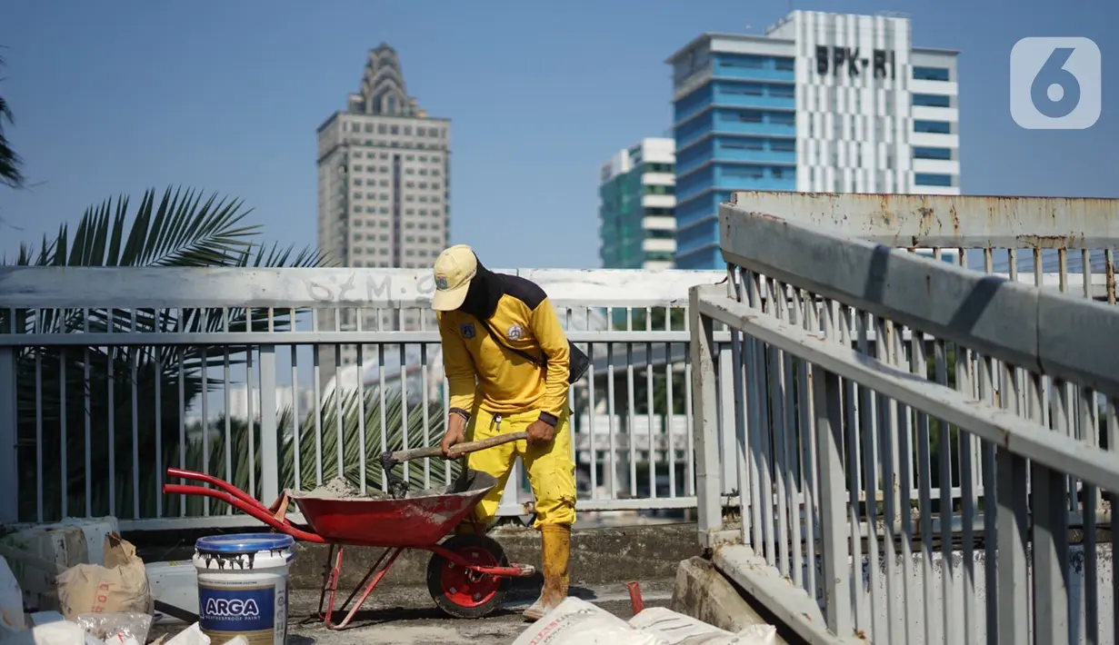 Petugas Bina Marga memerbaiki lantai Jembatan Penyeberangan Orang (JPO) yang berlubang di kawasan Tebet, Jakarta, Kamis (27/8/2020). Perbaikan dilakukan guna meningkatkan kenyamanan bagi pejalan kaki yang melintas. (Liputan6.com/Immanuel Antonius)
