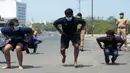 Orang-orang melakukan sit-up tanpa alas kaki sebagai hukuman karena keluar rumah selama pemberlakukan penguncian wilayah (lockdown) di Chennai, Rabu (1/4/2020). Pemerintah India menerapkan kebijakan karantina wilayah atau lockdown dalam memerangi Virus Corona COVID-19. (Arun SANKAR / AFP)