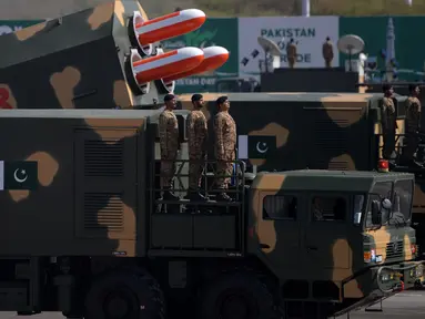 Sejumlah prajurit Pakistan berdiri di samping rudal siluman Babur saat parade Hari Militer Pakistan di Islamabad, Pakistan, (23/3). Parade ini memperingati Resolusi Lahore, perpisahan kaum Muslim dari Kerajaan Britania India. (AFP Photo / Aamir Qureshi)