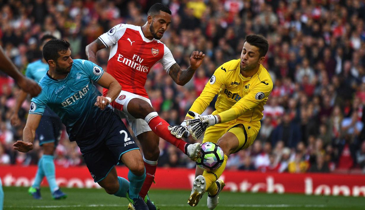 Theo Walcott (tengah) memborong dua gol saat Arsenal mengalahkan Swansea City 3-2 pada laga Premier League pekan ke-8 di Emirates Stadium, London (15/10/2016). (AFP/Justin Tallis)