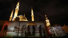 Masjid Al-Amin dan Katedral Christian Maronite saat diterangi cahaya bergambar masjid al-Aqsa dan gereja Makam Suci di Kota Tua Yerusalem di Beirut, Lebanon, (7/12). (AFP Photo/Anwar Amro)
