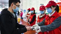 Sukarelawan memeriksa dokumen mahasiswa Universitas Teknologi Taiyuan di Stasiun Kereta Selatan Taiyuan, Taiyuan, Provinsi Shanxi, China, Jumat (10/4/2020). Gelombang pertama mahasiswa dengan tugas penelitian di Shanxi mulai kembali menjalani perkuliahan. (Xinhua/Chai Ting)