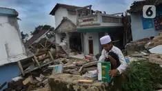 Seorang santri menyelamatkan Al-Qur'an dari puing banguan yang hancur akibat gempa di Pesantren Al Burok, Kampung Cisarua, Desa Sarampad, Cianjur, Jawa Barat, Rabu (21/11/2022). Gempa bumi dengan magnitude 5,6 di Cianjur Jawa Barat yang berpusat di darat 10 km barat daya embuat sejumlah rumah dan bangunan rusak. (merdeka.com/Arie Basuki)