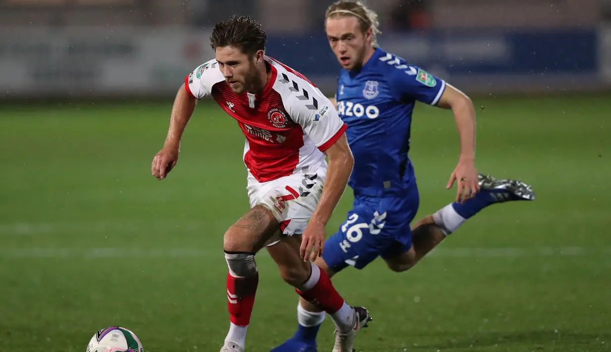 Gelandang Everton, Tom Davies, berebut bola dengan striker Fleetwood, Wes Burns, pada laga Piala Inggris, Kamis (24/9/2020) dini hari WIB. Everton menang 5-2 atas Fleetwood. (AFP/Alex Livesey/pool)