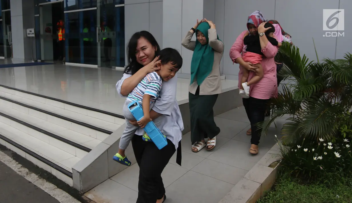 Para ibu berlari sambil melindungi kepala anak mereka dengan tangan saat simulasi bencana di Gedung Graha BNPB, Jakarta, Kamis (26/4). (Liputan6.com/Arya Manggala)