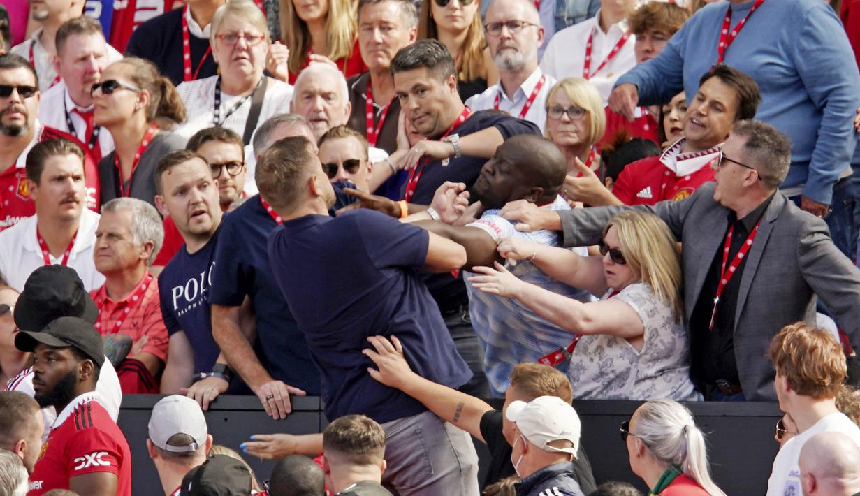 Sesama suporter Manchester United terlihat adu jotos saat menyaksikan tim kesayanganya tampil melawan Brighton and Hove Albion pada laga Liga Inggris di Stadion Old Trafford, Minggu (07/08/2022). (AP/Dave Thompson)