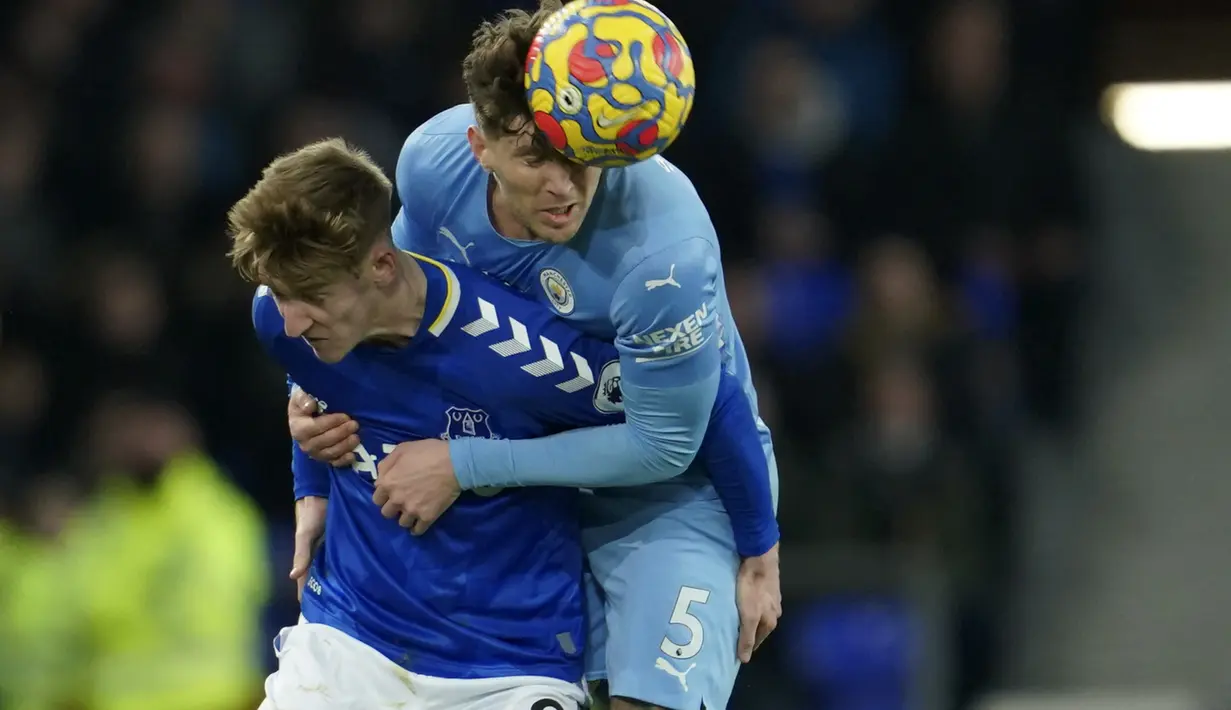 Penyerang Everton, Anthony Gordon berebut bola dengan bek Manchester City, John Stones pada pertandingan lanjutan Liga Inggris di Goodison Park di Liverpool, Inggris, Minggu (27/2/2022). Man City menang tipis atas Everton 1-0. (AP Photo/Jon Super)