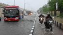 Sebuah bus melewati jalan yang tergenang air saat hujan lebat di New Delhi, India (1/9/2021). Hujan lebat yang terus mengguyur Kota New Delhi dalam dua hari berturut-turut dengan intentitas tinggi di hari kedua telah menyebabkan genangan banjir. (AFP/Prakash Singh)