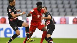 Pemain Bayern Munchen, Alphonso Davies, berusaha melewati pemain Fortuna Duesseldorf pada laga Bundesliga di Allianz Arena, Sabtu (30/5/2020). Bayern Munchen menang 5-0 atas Fortuna Duesseldorf. (AP/Christof Stache)
