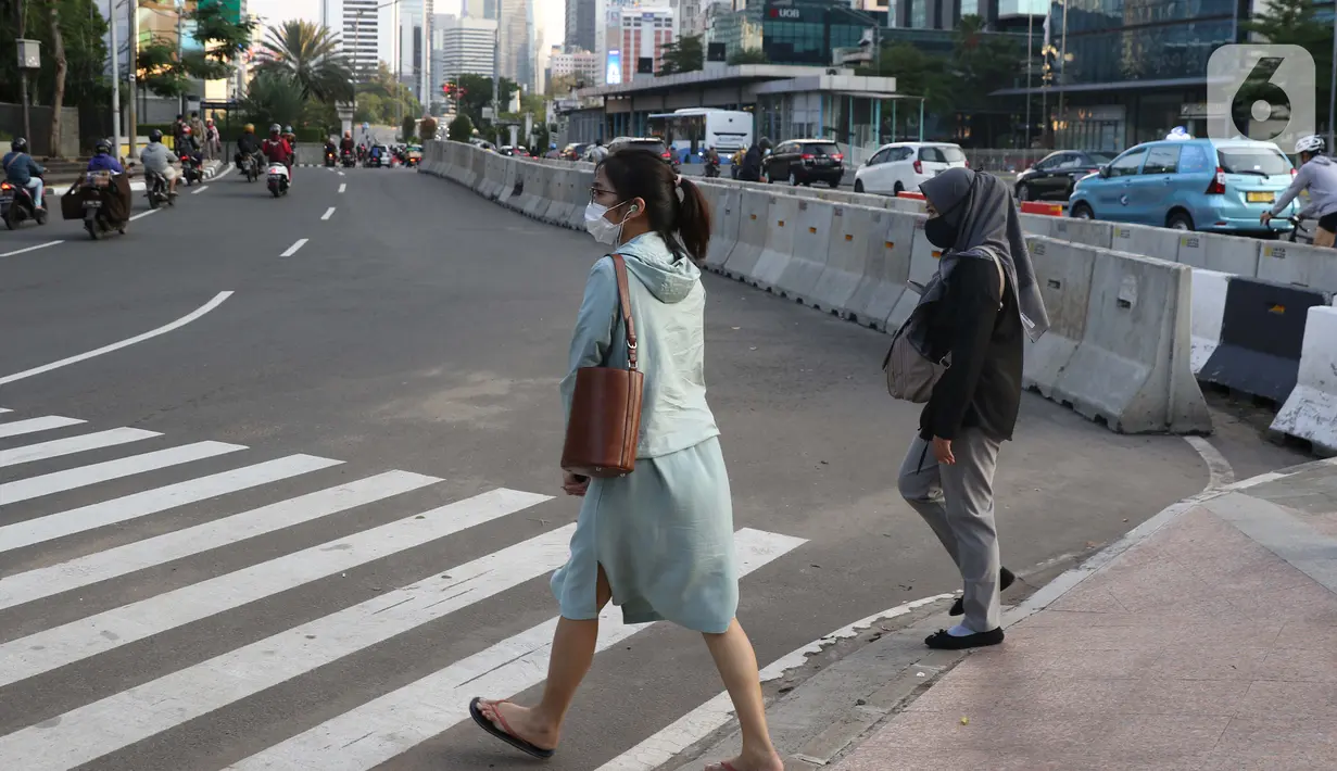 Pejalan kaki melintasi lajur penyebrangan Jalan Jenderal Sudirman, Jakarta, Rabu (23//9/2020). Menteri Keuangan Sri Mulyani Indrawati memastikan ekonomi nasional resesi pada kuartal III-2020, perekonomian Indonesia akan mengalami kontraksi hingga minus 2,9 persen. (Liputan6.com/Helmi Fithriansyah)