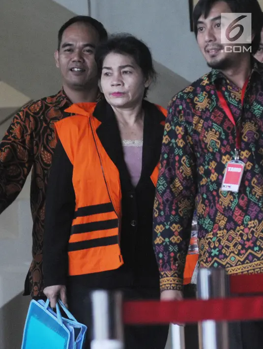 Hakim Adhoc Tipokor PN Medan Merry Purba usai menandatangani berkas P21 tahap 2 di Gedung KPK, Jakarta, Rabu (26/12). Merry mengenakan rompi tahanan dan dikawal petugas KPK. (Merdeka.com/Dwi Narwoko)