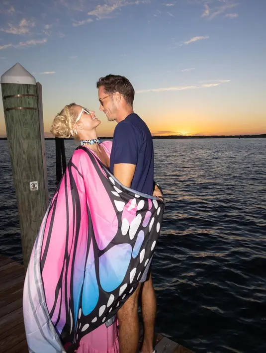 Ia mengenakan kemeja polo sutra berwarna biru tua dan celana pendek print. [instagram/parishilton]