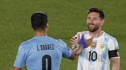 Penyerang Argentina Lionel Messi dan penyerang Uruguay Luis Suarez berjabat tangan sebelum laga Kualifikasi Piala Dunia 2022 Zona Amerika Selatan di Monumental stadium, Senin (11/10/2021) WIB. Duel ini menjadi momen reuni dua mantan pemain Barcelona, Messi dan Suarez. (AP Photo/Natacha Pisarenko)