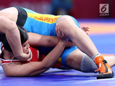 Pegulat putri Indonesia, Ridwan Ridha Wahyadaniyaty bertarung melawan Medet Kyzy Aiperi dari Kirgizstan pada kelas putri 76 Kg di JCC Senayan, Selasa (21/8). Pada perdelapan final, Ridha kalah atas lawanya dengan skor 0-12. (Liputan6.com/Fery Pradolo)