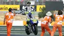 Valentino Rossi berdiri di atas motornya saat merayakan kemenangan dalam MotoGP di Portugal pada September 2007. (AFP/Francisco Leong)