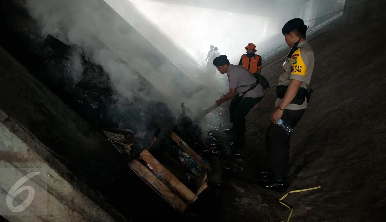 Satuan Brimob memeriksa tumpukan sampah yang berada di bawah Fly over jalan Dewi Sartika, Cawang, Jakarta, Rabu (19/4). Kepolisian mengimbau masyarakat untuk meningkatkan pengawasan di lingkungan masing-masing. (Liputan6.com/Gempur M. Surya)