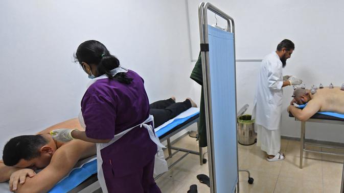 Spesialis melakukan pengobatan hijama atau terapi bekam basah kepada pasien di sebuah klinik di Ajman, Uni Emirat Arab, Kamis (15/8/2019). Hijama berfungsi untuk membuang darah yang telah rusak atau teroksidasi karena tingginya oksidan dalam tubuh. (KARIM SAHIB/AFP)