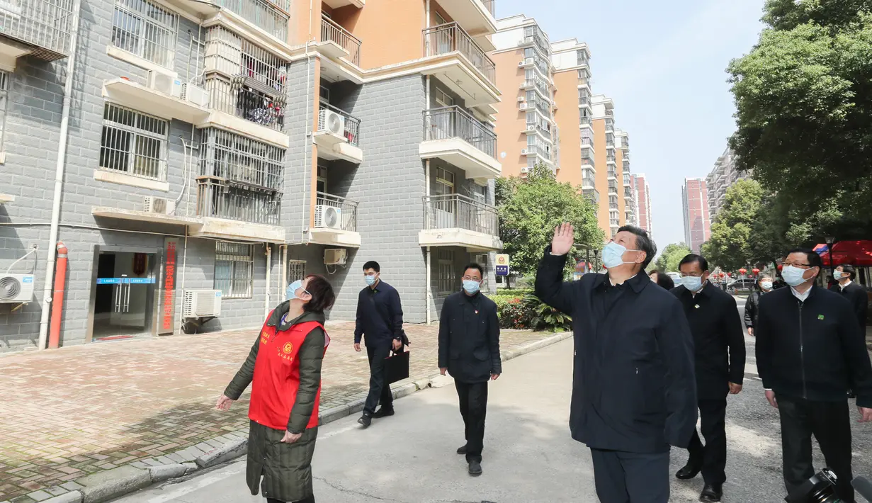Presiden China Xi Jinping melambaikan tangan kepada warga yang dikarantina di rumah serta menyampaikan salam kepada mereka di sebuah area permukiman di Wuhan, 10 Maret 2020. Xi melakukan inspeksi terkait upaya pencegahan dan pengendalian wabah virus corona di Wuhan. (Xinhua/Xie Huanchi)