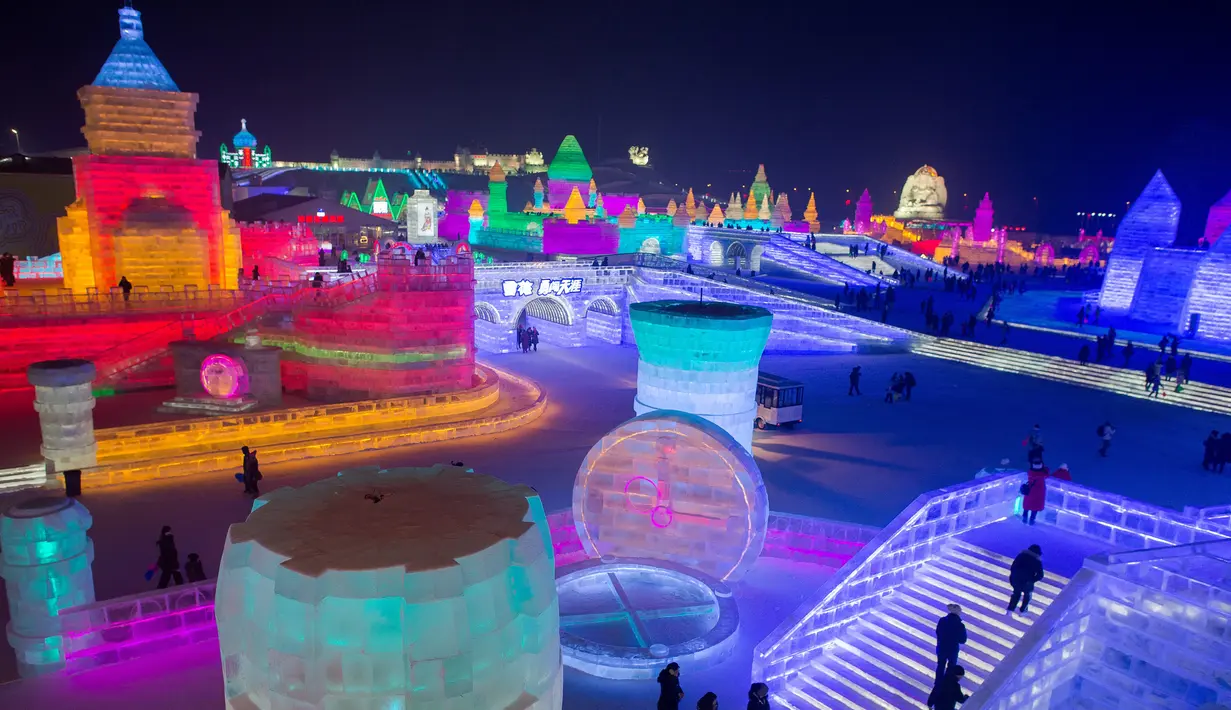 Suasana saat Festival Es dan Salju digelar di Harbin, Tiongkok, Rabu (4/1). Festival musim dingin legendaris tersebut kembali menampilkan pahatan dan replika sejumlah ikon dunia berukuran raksasa yang terbuat dari es.( AFP PHOTO / Nicolas ASFOURI)