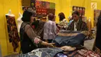Pengunjung melihat kain selama pameran Karya Kreatif Indonesia (KKI) di Jakarta, Jumat (12/7/2019). Pameran KKI 2019 ini berlangsung selama 3 hari menampilkan produk-produk UMKM RI mulai dari kain, pakaian, tas, hingga berbagai kuliner seperti kopi buatan anak negeri. (Liputan6.com/Angga Yuniar)