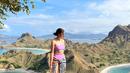 Dwi Jayanti  mengunggah foto dirinya berpose di atas bukit dalam balutan bikini berwarna ungu. Bikini ini memiliki model one shoulder. (Instagram/tynadwijayanti)