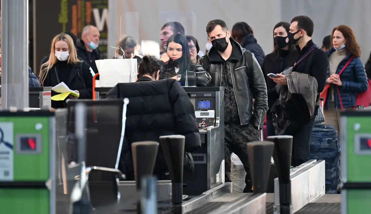 Pelancong menunggu di konter check-in sebelum penerbangan mereka di bandara Boryspil, luar Kiev, 13 Februari 2022. Ukraina berjanji menjaga wilayah udaranya terbuka untuk perjalanan internasional setelah negara Barat memperingatkan pasukan Rusia dapat menyerang kapan saja. (Sergei Supinsky/AFP)