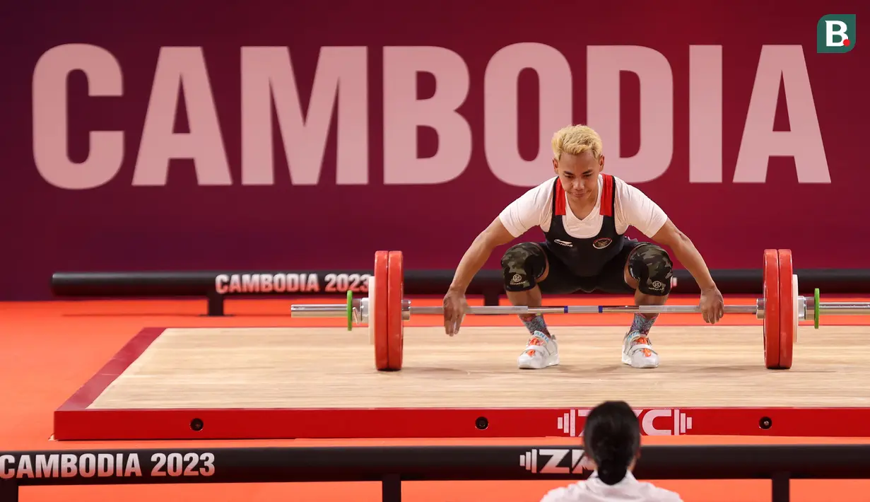 <p>Atlet angkat besi Indonesia, Eko Yuli Irawan berkompetisi pada nomor angkat besi putra 61 kg SEA Games 2023 di Taekwondo Hall Olympic Complex, Phnom Penh, Kamboja, Sabtu (13/05/2023). (Bola.com/Abdul Aziz)</p>