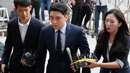 Mantan anggota boyband BIGBANG, Seungri (tengah) tiba untuk menjalani interogasi di Kantor Polisi Metropolitan Seoul, Rabu (28/8/2019). Polisi memanggil Seungri untuk memberikan keterangan atas tuduhan kasus perjudian di luar negeri. (AP/Ahn Young-joon)