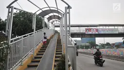 Pejalan kaki melintasi jembatan penyeberangan orang (JPO) di Jalan Yos Sudarso, Jakarta, Kamis (8/11). Kondisi JPO yang rusak menggangu kenyamanan dan keselamatan pejalan kaki. (Merdeka.com/Iqbal Nugroho)