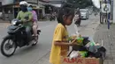 Seorang anak mengambil mi instan dan telur gratis di Jalan Raya Cibubur-Bojong Kulur, Bogor, Kamis (9/4/2020). Di beberapa pinggir jalan Kawasan Jabotabek saat ini banyak aksi solidaritas oleh warga dengan menyediakan bahan makanan gratis di tengah pandemi virus corona. (merdeka.com/Arie Basuki)