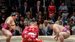 Presiden AS Donald Trump (dua kiri) didampingi PM Jepang Shinzo Abe (kiri) menyaksikan Tokyo Grand Sumo Tournament di Stadion Ryogoku Kokugikan, Tokyo, Jepang, Minggu (26/5/2019). Trump merupakan Presiden AS pertama yang menonton sumo di Jepang. (AP Photo/Evan Vucci)