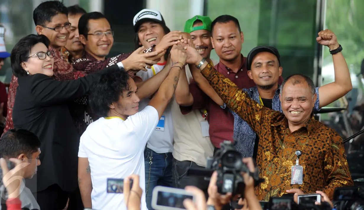 Pimpinan KPK Agus Rahardj, Laode Muhammad Syarif, Basaria Panjaitan dan Alexander Marwata saling berjabatan tangan dengan grup band Slank sebelum Slank menggelar konser di halaman Gedung KPK, Jakarta, Senin (22/2). (Liputan6.com/Helmi Afandi)