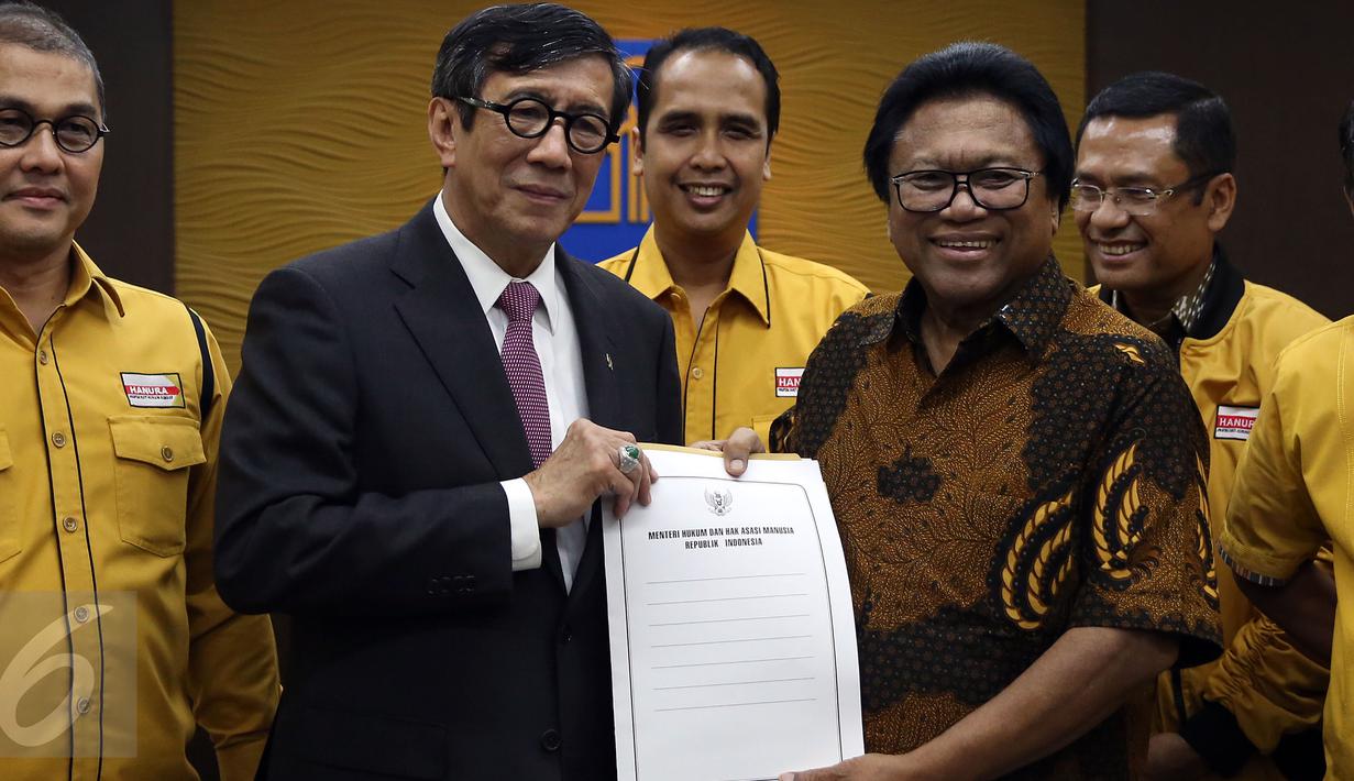 Menkumham Yasonna Laoly (kedua kiri) bersama Ketua Umum Partai Hanura Oesman Sapta Odang (OSO) menunjukan keputusan struktur organisasi Partai Hanura usai memberikan keterangan pers di kantor Kemenkumham, Jakarta, Rabu (2/1). (Liputan6.com/Johan Tallo)