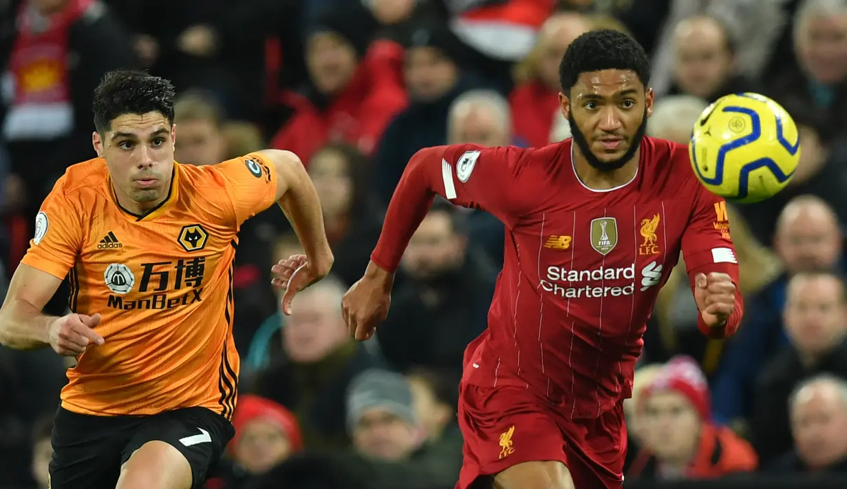Bek Liverpool, Joe Gomez (kanan) berebut bola dengan  gelandang Wolverhampton Wanderers, Pedro Neto pada pekan ke-20 Liga Inggris 2019-2020 di Anfield, Minggu (29/12/2019). Liverpool semakin perkasa di Premier League setelah menang 1-0 atas Wolverhampton. (Paul ELLIS / AFP)