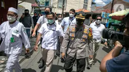 Anggota Polda Metro Jaya mendatangi kediaman Rizieq Shihab di kawasan Petamburan, Jakarta, Rabu (2/12/2020). Kedatangan tersebut untuk memberikan surat pemanggilan kepada Rizieq Shihab terkait acara Maulid Nabi dan resepsi pernikahan putrinya pada 14 November 2020 lalu. (Liputan6.com/Faizal Fanani)