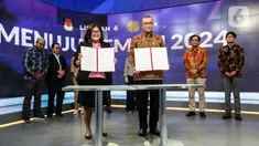 Ketua Komisi Pemilihan Umum (KPU) Hasyim Asy'ari (tengah kanan) bersama CFO KLY Octaviany Sarimawan (tengah kiri) menunjukkan dokumen kerja sama saat acara penandatanganan MoU antara Emtek dengan KPU di SCTV Tower, Jakarta, Selasa (30/8/2022). Kerja sama KPU dengan Emtek ini terkait sosialisasi Pemilihan Umum yang akan diselenggarakan 2024 mendatang. (Liputan6.com/Johan Tallo)