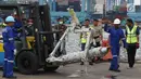Petugas memindahkan salah satu bagian dari roda pesawat Lion Air PK-LQP JT 610 di Pelabuhan JICT 2, Jakarta, Senin (5/11). Bagian tersebut dipindah untuk dilakukan identifikasi dan pengecekan lebih lanjut oleh KNKT. (Liputan6.com/Helmi Fithriansyah)