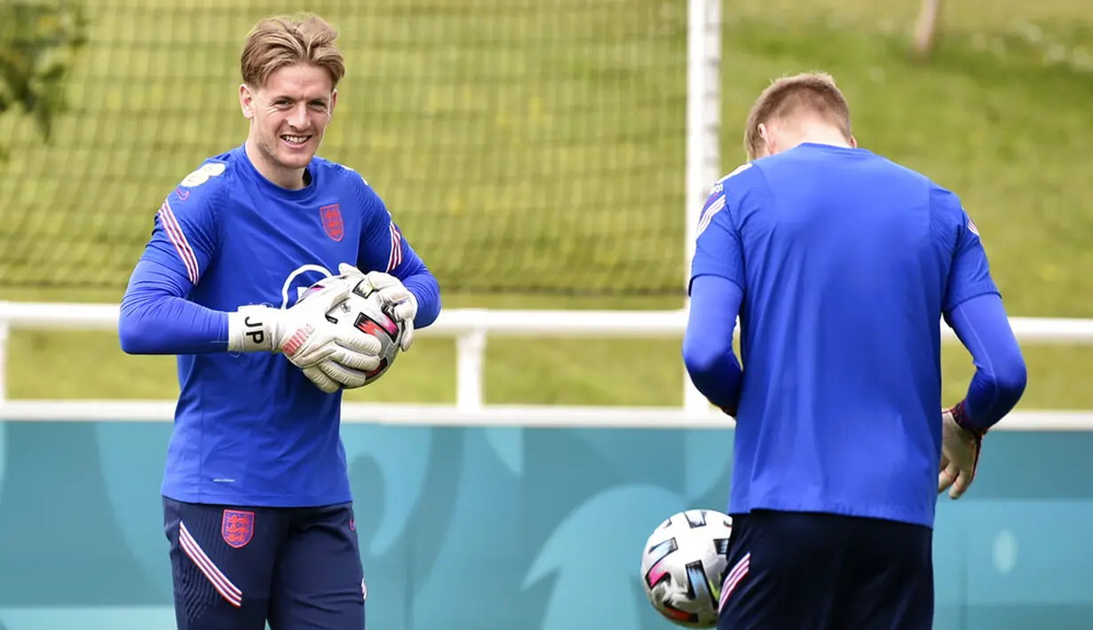 Penjaga gawang Inggris Jordan Pickford (kiri) memegang bola saat sesi latihan di St George's Park, Burton upon Trent, Inggris, Senin (5/7/2021). Inggris akan melawan Denmark pada pertandingan semifinal Euro 2020. (AP Photo/Rui Vieira)