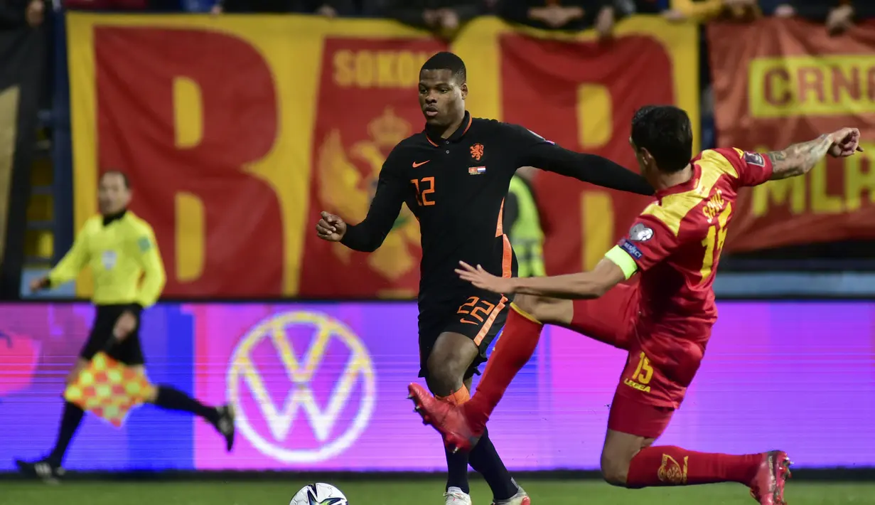Bek Belanda, Denzel Dumfries berusaha melewati pemain Montenegro, Stefan Savic pada pertandingan grup G  kualifikasi Piala Dunia 2022 di stadion City di Podgorica, Montenegro, Minggu (14/11/2021). Belanda bermain imbang atas Montenegro 2-2. (AP Photo/Risto Bozovic)