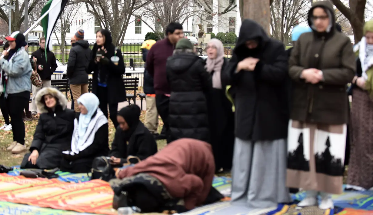 Warga Muslim menggelar Salat Jumat berjamaah di depan Gedung Putih, Jumat (8/12). Selain melakukan salat Jumat, mereka juga menggelar protes terhadap keputusan Presiden AS Donald Trump mengakui Yerusalem sebagai ibu kota Israel. (Eric BARADAT / AFP)