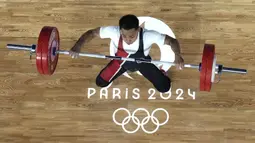 Lifter Indonesia, Eko Yuli Irawan berusaha melakukan angkatan pada cabor angkat besi Olimpiade Paris 2024 di South Paris Arena, Paris, Prancis, Rabu (07/08/2024). (AP Photo/Pool/Dita Alangkara)